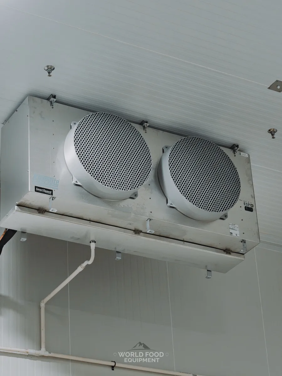 Refrigeration evaporator mounted on an insulated ceiling panel.